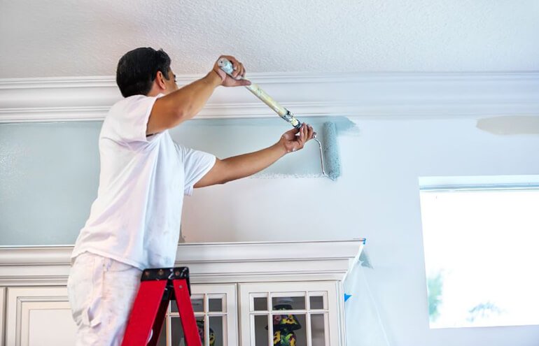 A man paint apartment painting services with brush